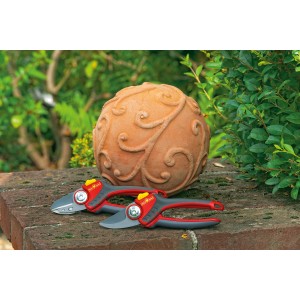 Wolf Gartenschere RR 2500 Comfort Plus, 2-schneidig, mit rutschfestem Griff auf Steinmauer.