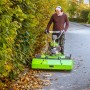 Mann nutzt Zipper Kehrmaschine ZI-KM1000 mit Schneeschild zum Laub kehren.