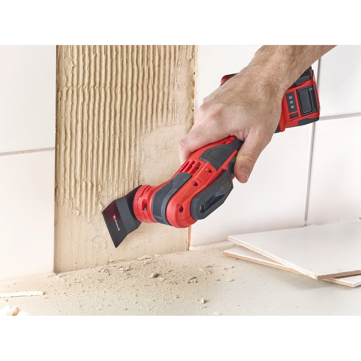 Einhell Multitool im Einsatz zum Entfernen von Fliesenkleber. Zubehör für Multifunktionswerkzeuge.