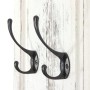 MCW Wandgarderobe H33 2er-Set Weiß Shabby mit zwei Metallhaken an weißer Holzpaneelwand.