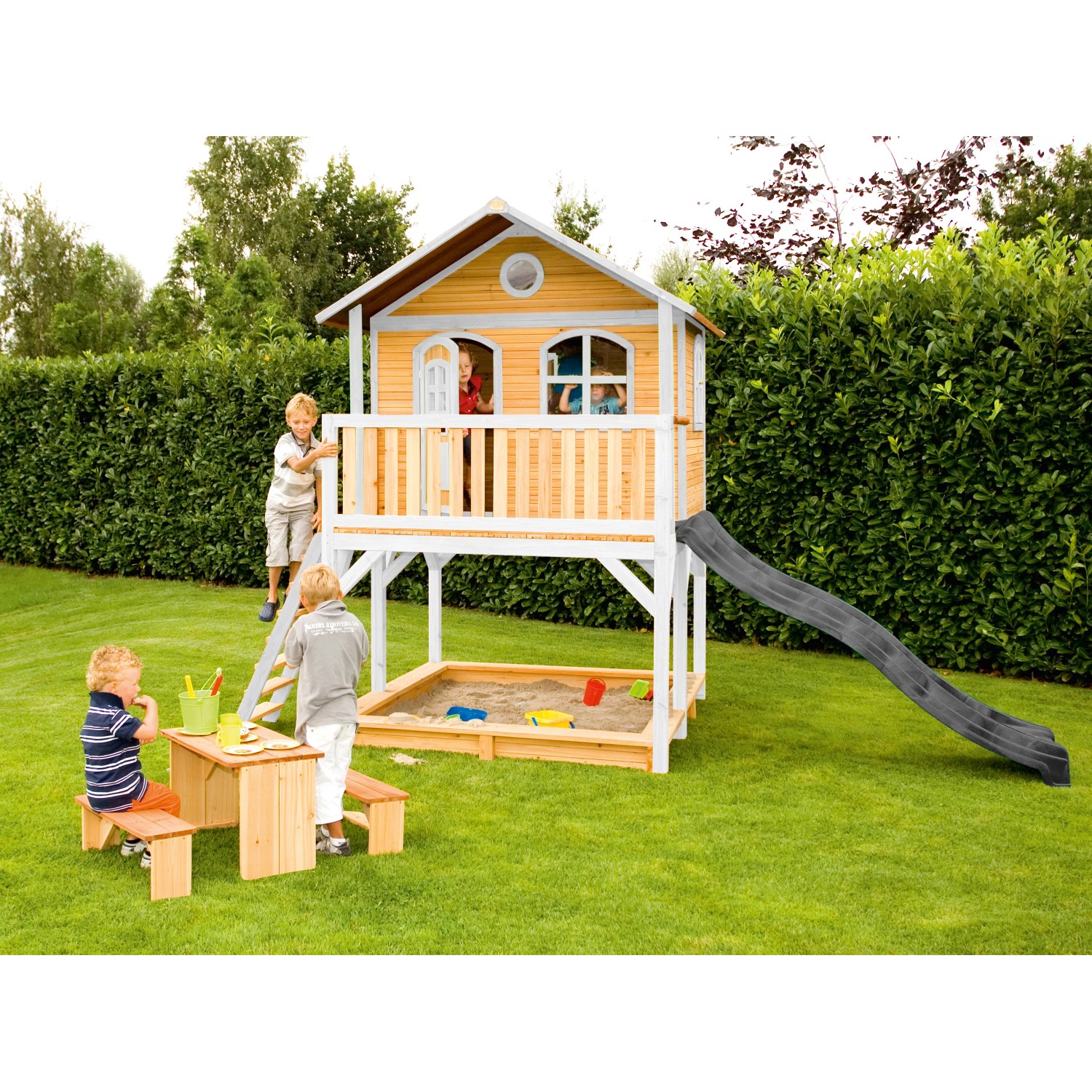Axi Marc Spielhaus mit Rutsche, Sandkasten und Picknicktisch im Garten.