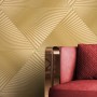 Goldene Vliestapete mit modernem, strukturiertem Grafikmuster im Wohnzimmer. Luxuriöse Wandgestaltung.