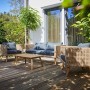 4-teiliges Lounge-Set Junee aus Polyrattan in Natur mit anthrazitfarbenen Auflagen und Holztisch.