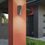 Moderne, anthrazitfarbene Trio LED-Außenwandleuchte Tay mit Lichteffekt an einer Hauswand.