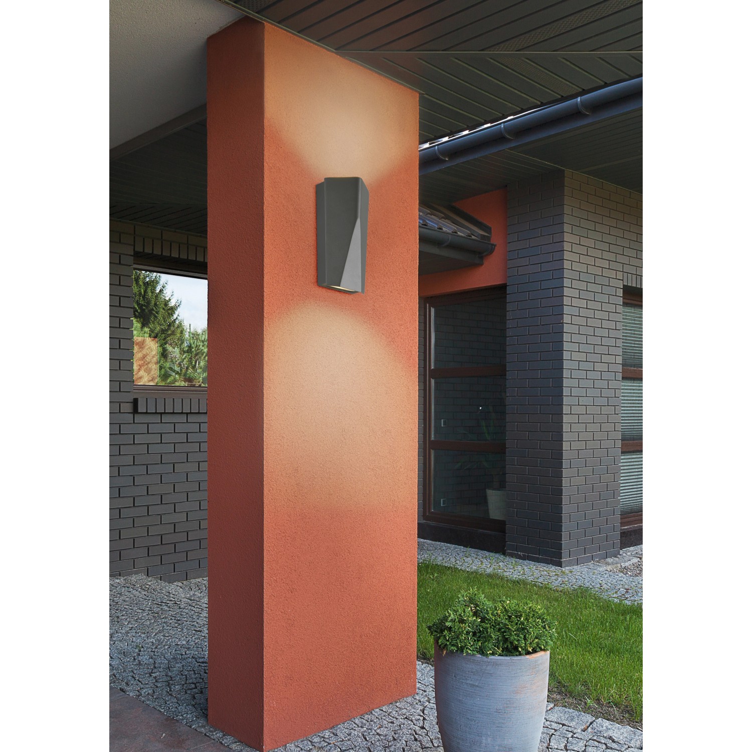 Moderne, anthrazitfarbene Trio LED-Außenwandleuchte Tay mit Lichteffekt an einer Hauswand.