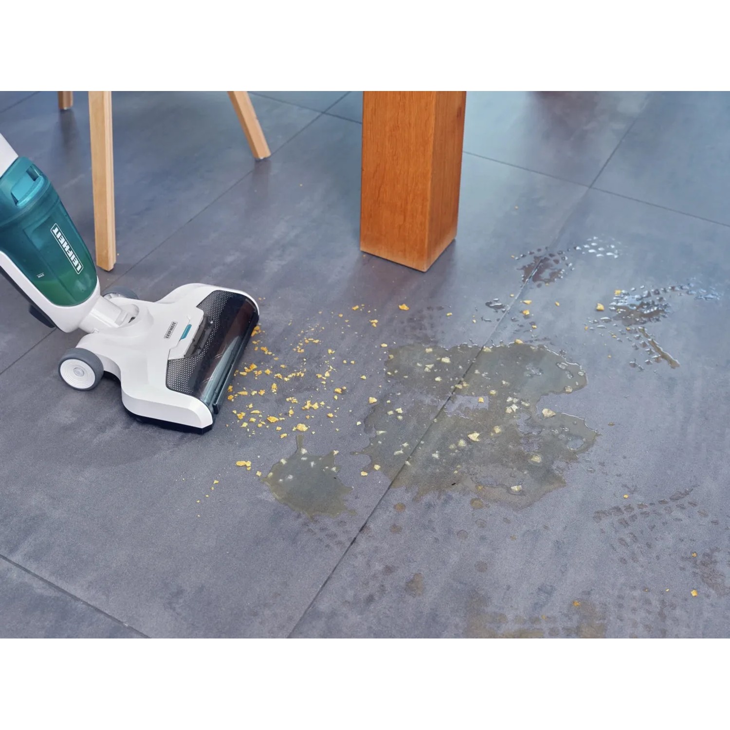 Leifheit Akku-Saugwischer Regulus Aqua PowerVac in Aktion auf Fliesenboden mit Schmutz.