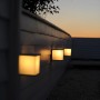 Anthrazitfarbene Lutec Box Cube Außenwandleuchten an weißer Wand im Dämmerlicht.
