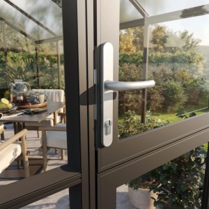 Detailaufnahme: Türgriff des KGT Gewächshaus Galant IV, Aluminiumfarben. Im Hintergrund Gartenmöbel.