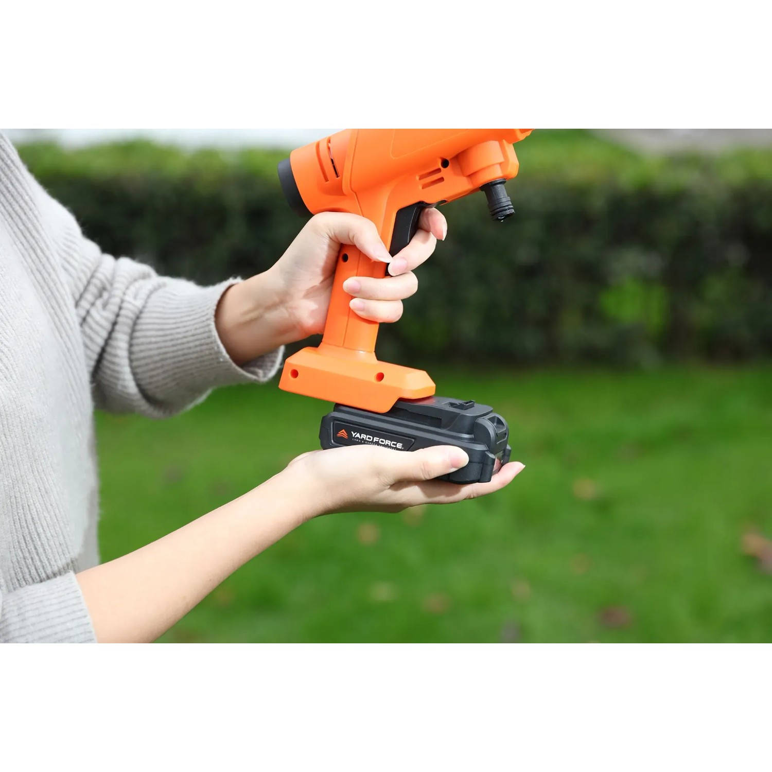 Yard Force Akku-Mitteldruckreiniger LW C02B, 20 V, mit Akku und Ladegerät in der Hand.