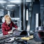 Frau schleift Metall mit Bosch Vliesschleifpad Expert N880 (2-teilig, 115x140mm).