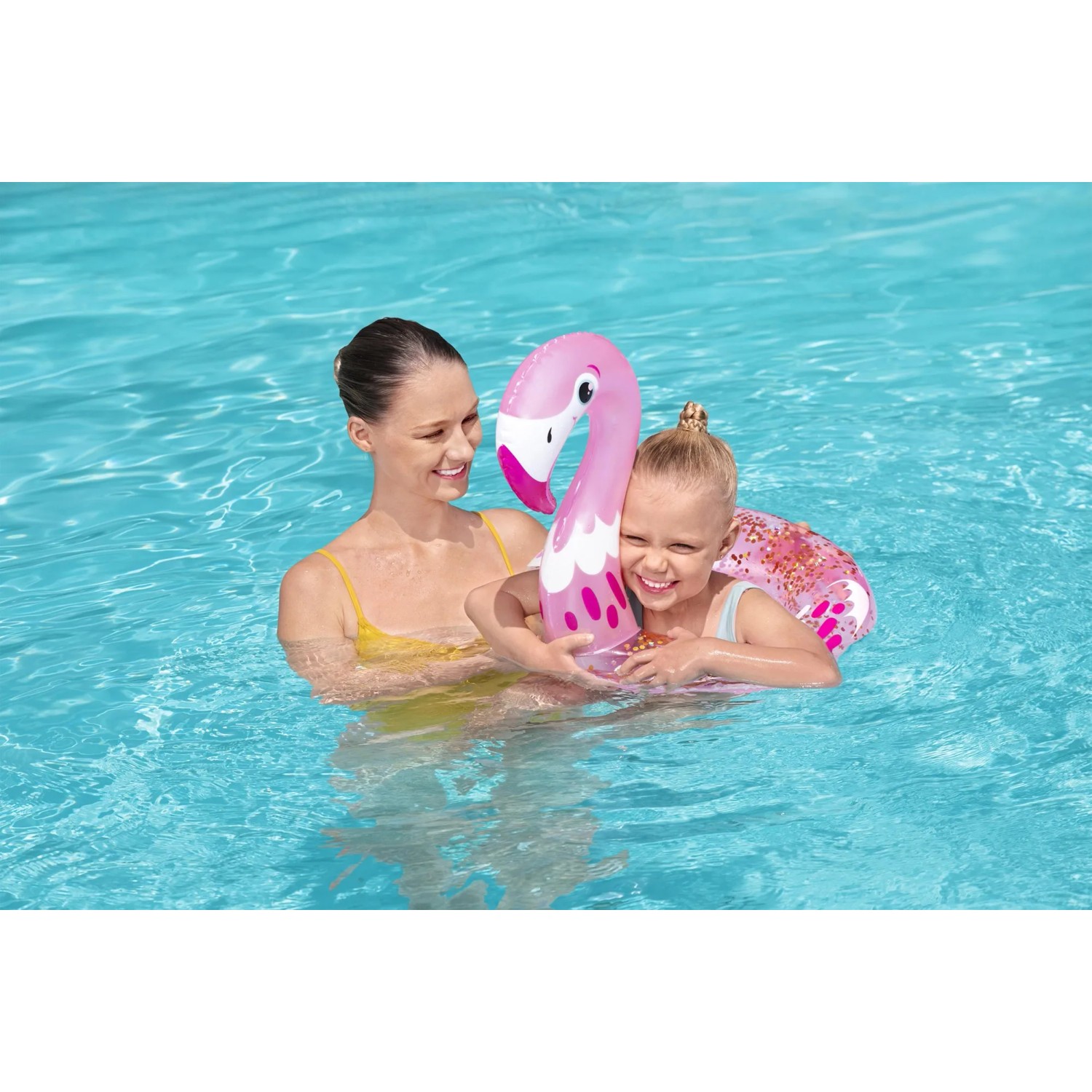 Mutter und Kind mit glitzerndem Bestway Schwimmring (Flamingo) im Pool.