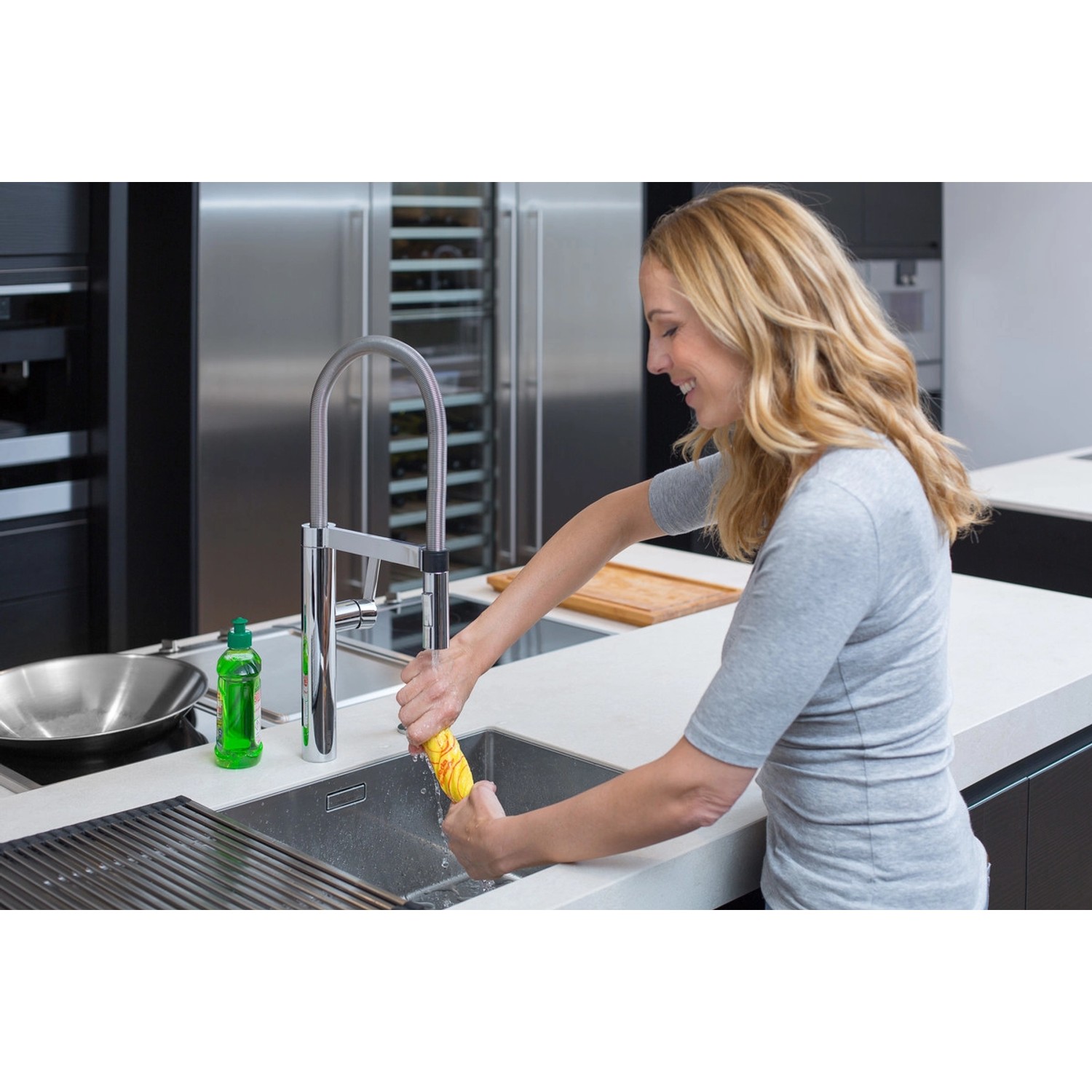 Frau wringt Vileda Allzwecktuch in Spüle aus. 6er-Pack Wischtücher mit Geruchsstopp.