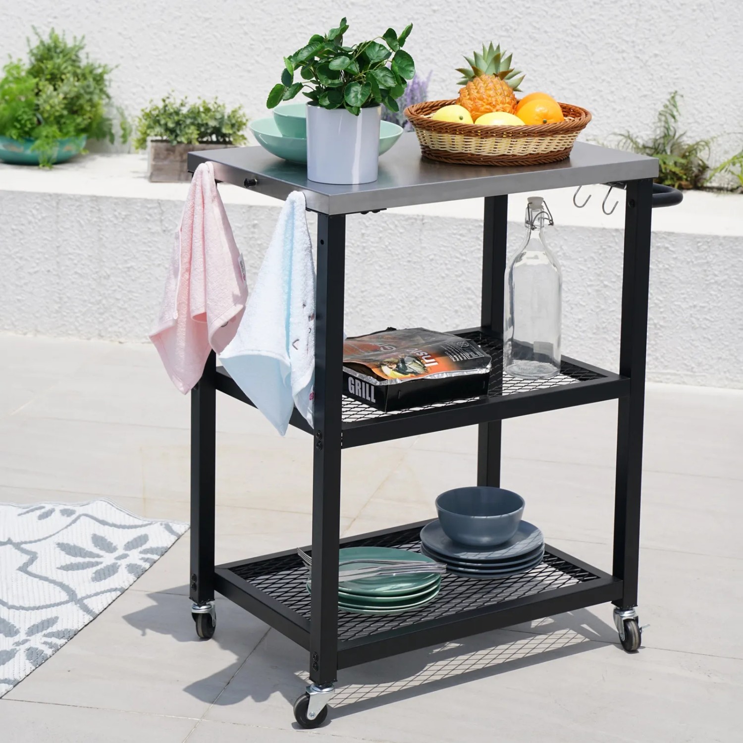 Schwarzer Taino Netis Grillwagen mit Edelstahlplatte, Rollen und drei Ablageflächen für Balkon, Garten oder Terrasse.