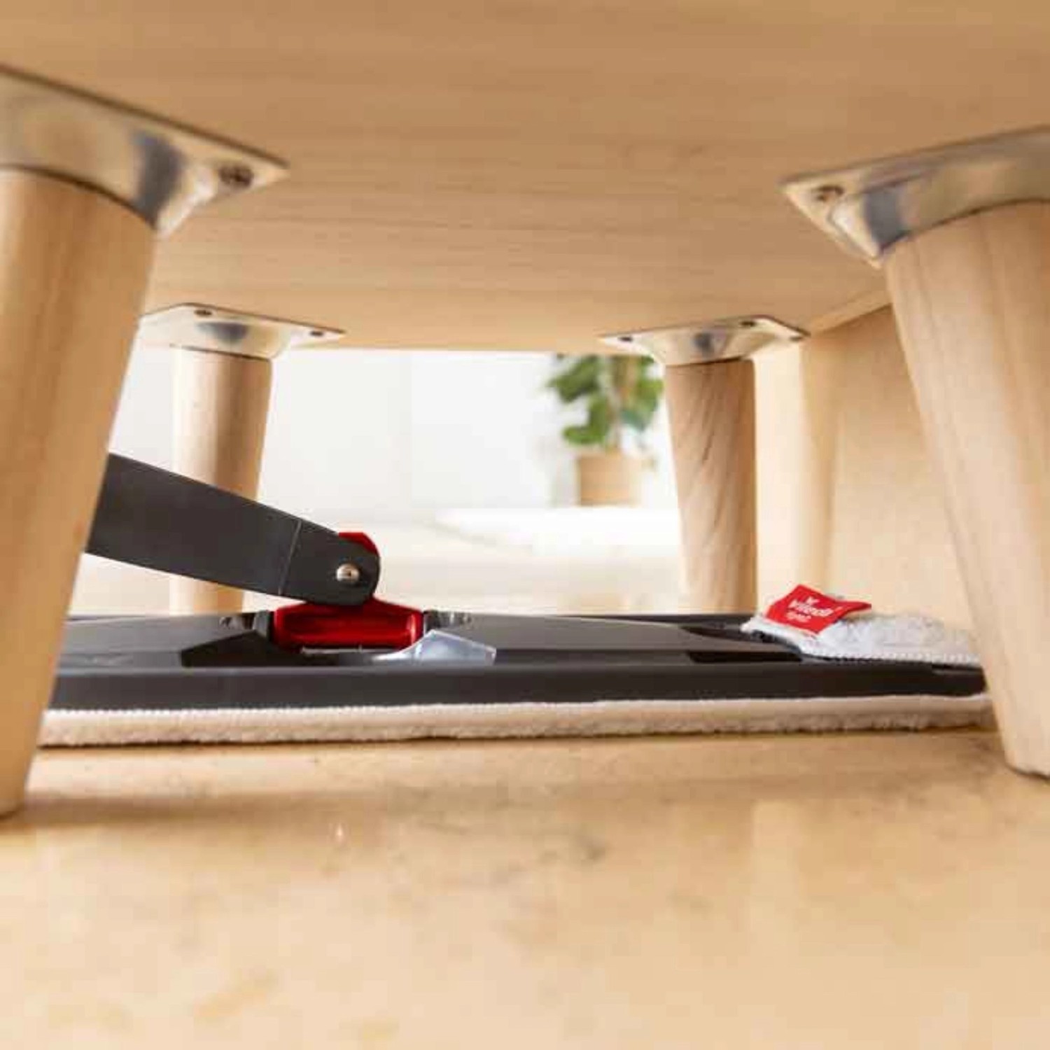 Vileda H2PrO Flachwischer im Einsatz unter Tisch, ideal für schwer erreichbare Stellen.