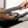 Fackelmann Bratpfanne Statement 24 cm mit Steak und Zange auf Induktionsherd.