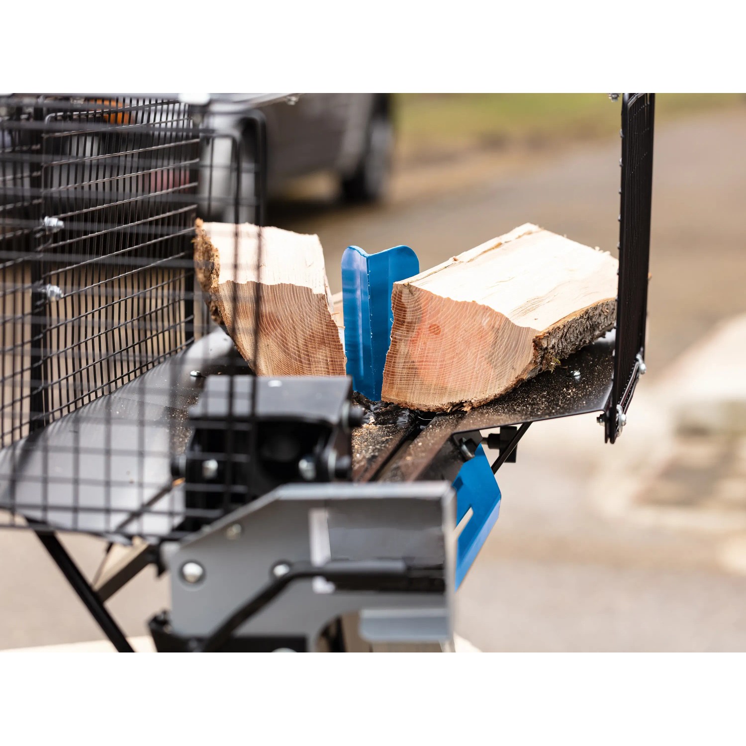 Scheppach HL460 Holzspalter liegend mit Holzscheit vor blauem Spaltkeil.