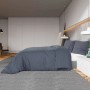 Anthrazitfarbenes Baumwoll-Bettwäsche-Set mit Deckenbezug und zwei Kissenbezügen auf einem Bett.