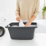 Anthrazitfarbene Rotho Wäschewanne Flowers 25 l mit Wäsche befüllt.
