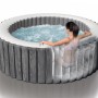 Intex Greywood Deluxe aufblasbarer Whirlpool mit sprudelndem Wasser und einer Person im Pool.