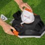 Flowclear Aquarover Poolroboter in Schwarz/Weiß wird auf Rasen bedient.