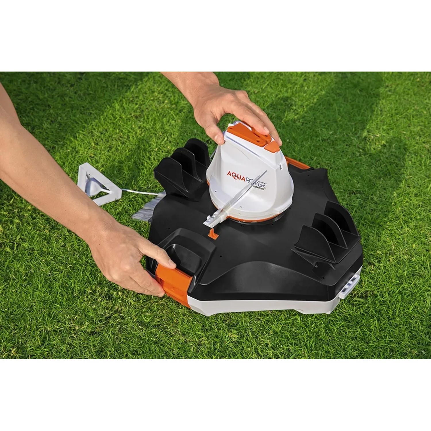 Flowclear Aquarover Poolroboter in Schwarz/Weiß wird auf Rasen bedient.