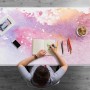 Bunte Schreibtischunterlage mit Süßigkeitenflecken-Design in Rosa, Lila, Orange. Person zeichnet am Schreibtisch. Bürobedarf.