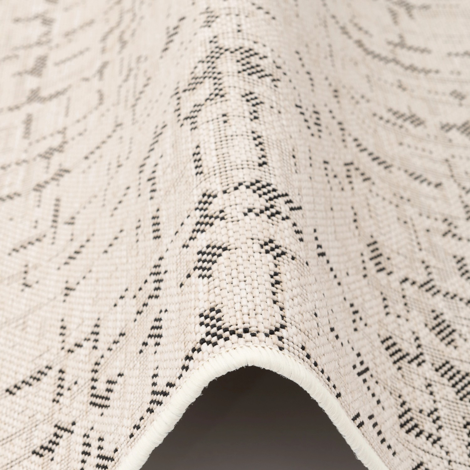 Detailansicht: Runder, creme-schwarzer Snapstyle In & Outdoor Teppich Oslo mit skandinavischem Muster.