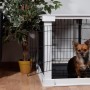 Weiße Hundebox Indoor mit Tischoberfläche und kleinem Hund darin.