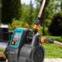 Gardena Haus- und Gartenautomat 6000/6 LCD Inox mit Display und angeschlossenen Gartenschläuchen.