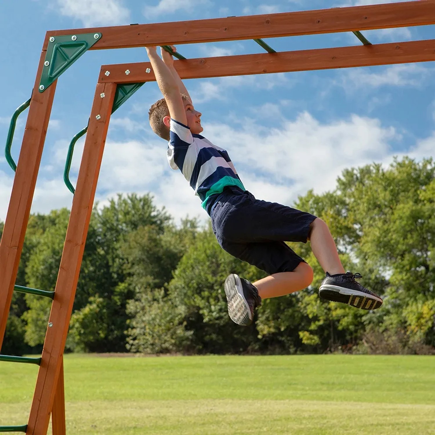 Junge hangelt an Affenleiter des Backyard Discovery Skyfort II Spielturms.