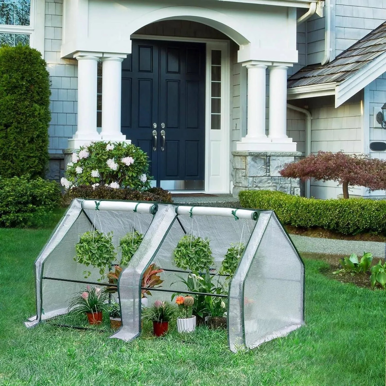 Weißes WOLTU Foliengewächshaus mit Metallrahmen und Pflanzen im Garten.