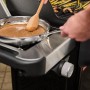 Weber Gasgrill EP-435: Seitenbrenner mit Pfanne und Sauce, ideal für Beilagen beim Grillen.