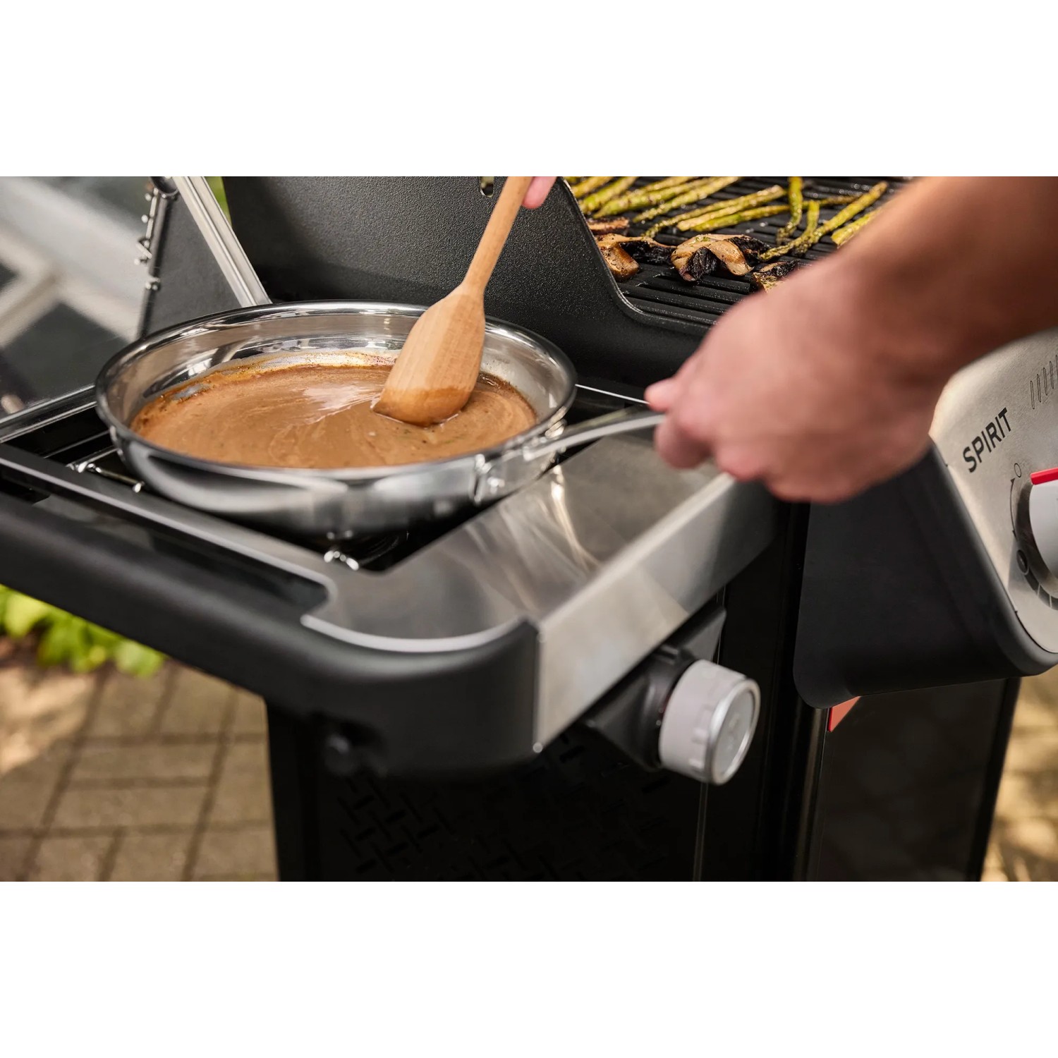 Weber Gasgrill EP-435: Seitenbrenner mit Pfanne und Sauce, ideal für Beilagen beim Grillen.