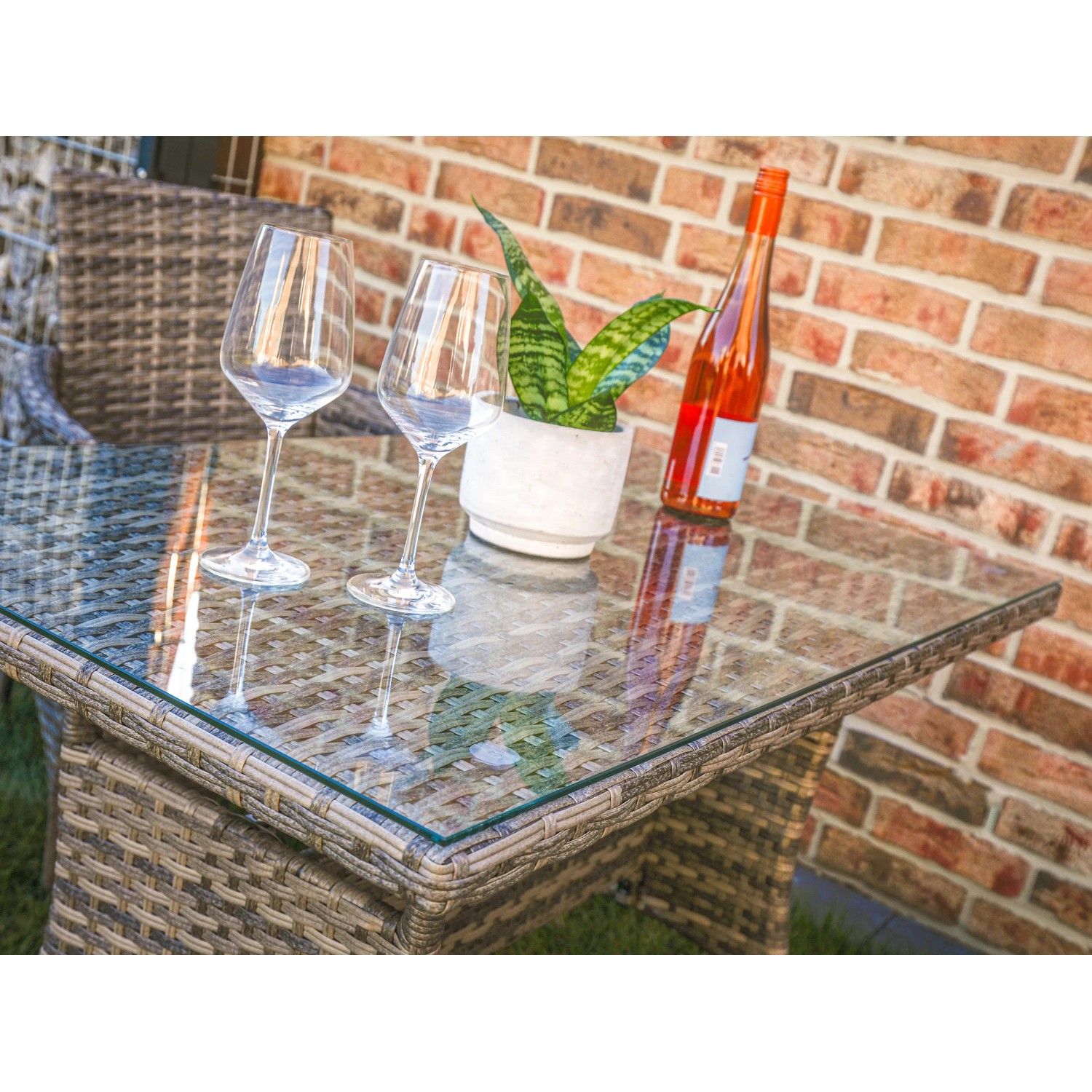 Detailansicht des Acamp Lounge-Sets Nina: Tisch mit Glasplatte, Gläser, Pflanze und Getränk. Balkonmöbel.