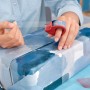 Frau verpackt Geschenk mit Tesa Film Kristall-Klar und Mini-Abroller am Finger.