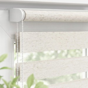 Beiges Doppelrollo mit abwechselnd blickdichten und transparenten Streifen am Fenster. Klemmfix Duo Rollo mit Seitenzug.