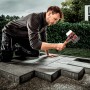 Mann verlegt Pflastersteine mit Halder Simplex Schonhammer (Ø 60 mm) mit Gummi- und Superplastikeinsatz.