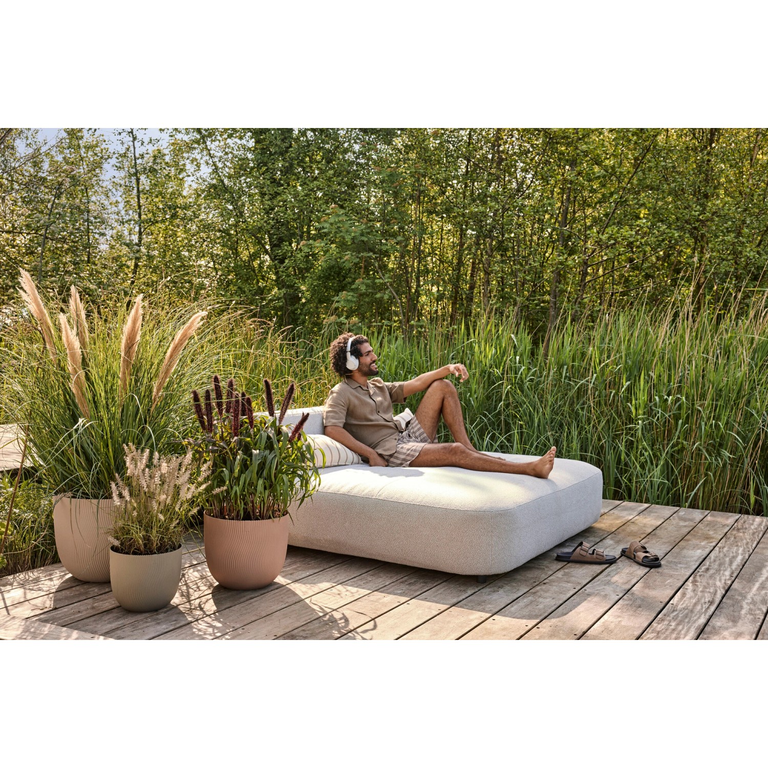 Elho Blumentöpfe Sereh in Grün und Beige, Größen Ø 47 cm und kleiner, mit Bepflanzung auf Holzterrasse.