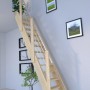 StarWood Treppe Samos Fichte mit Holz-Edelstahlgeländer und verjüngten Stufen im Innenraum.