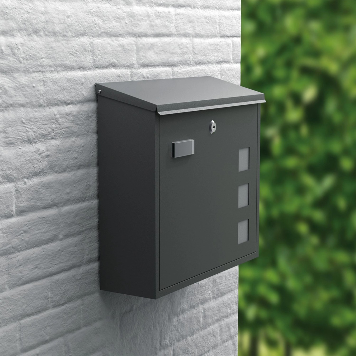 Matt anthrazitfarbener Basi Briefkasten BK 350M mit Schloss und Sichtfenstern an einer weißen Wand.