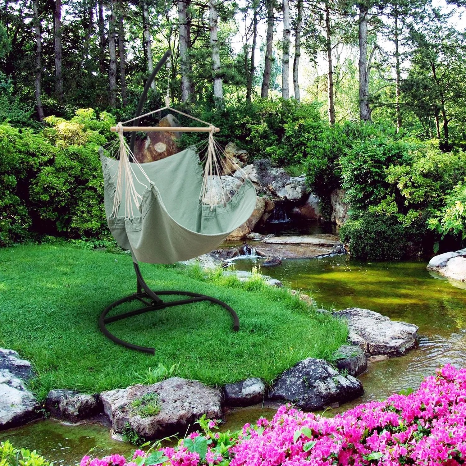 AMANKA XL-Hängesessel Aqua mit Gestell in einem grünen Garten am Teich mit pinken Blumen. Ideal zum Entspannen.