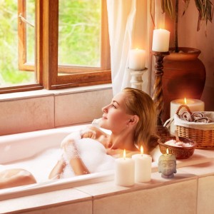 Grauer Buddha Teelichthalter aus Keramik, 9,5 cm hoch, mit brennendem Teelicht im Badezimmer.