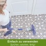 Frau wischt Fliesenboden mit dem Bona Premium Spray Mop. Reiniger und Mikrofaserpad für streifenfreie Sauberkeit.