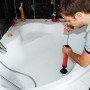 Mann benutzt Rothenberger Pömpel RoPump in Badewanne zur Abflussreinigung.