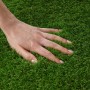 Nahaufnahme: Hand berührt weichen, grünen Karat Kunstrasen Tosca (35mm). Ideal für Balkon & Garten.