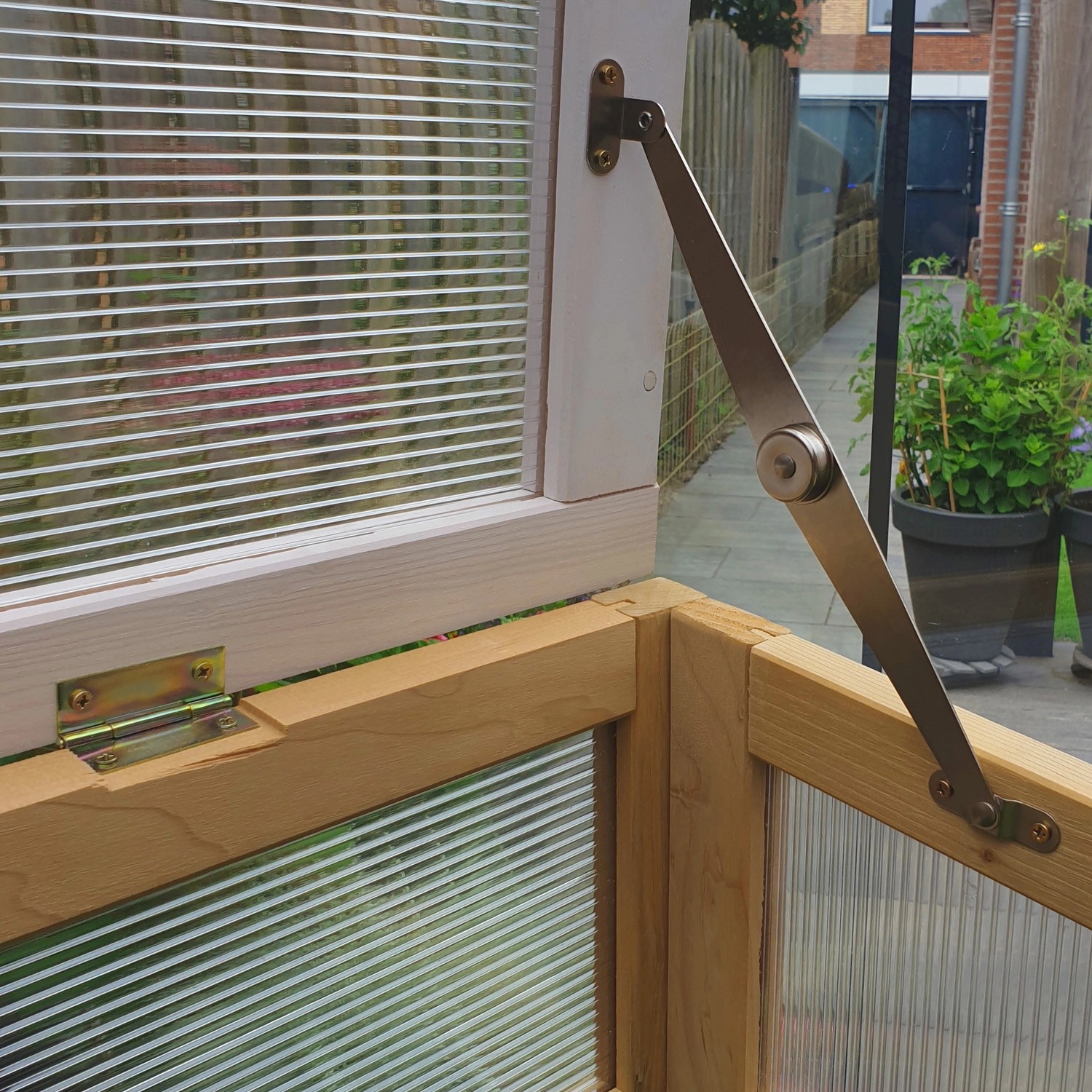 Detailaufnahme: Axi Hochbeet mit Gewächshaus, braunes Holz, weiße Akzente, geöffneter Aufsatz.