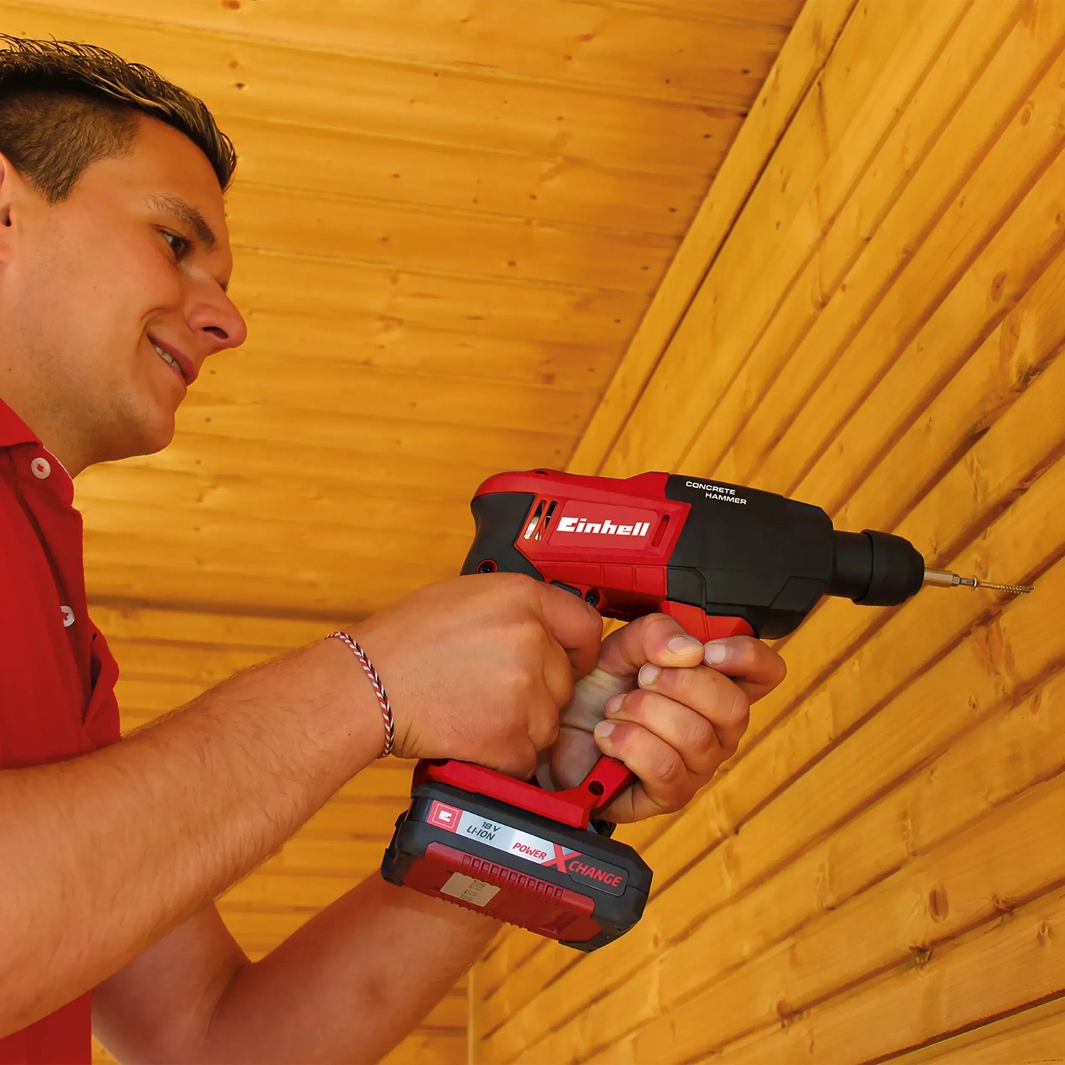 Einhell Akku-Bohrhammer TE-HD 18 Li-Solo beim Bohren in Holz. Rot-schwarzes Design, Teil der Power X-Change Familie.