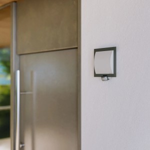 Steinel Außenwandleuchte L 20 S Anthrazit, quadratisch, mit schwenkbarem Bewegungsmelder an weißer Wand.