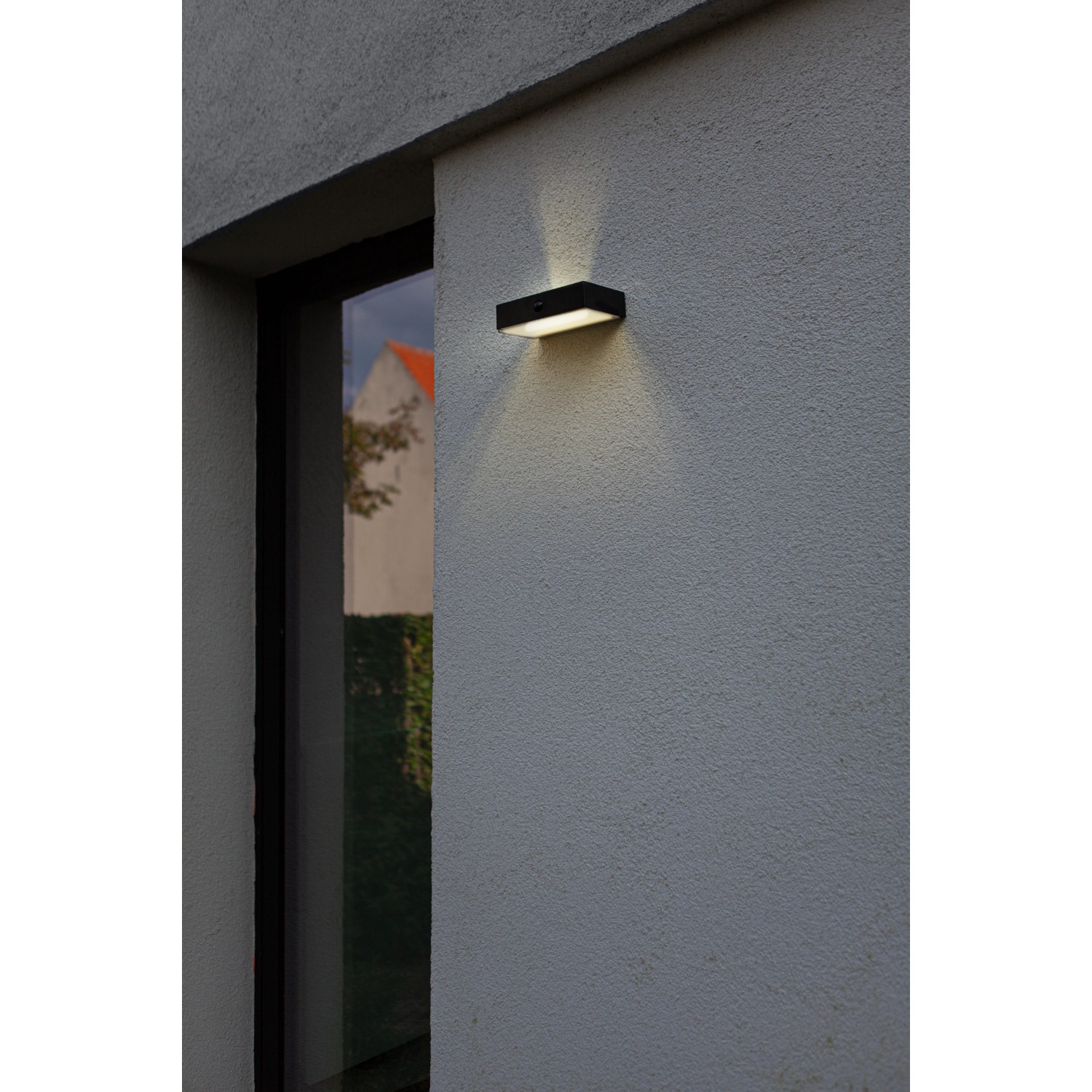 Schwarze, eckige Lutec LED Solar Wandleuchte Fadi mit Bewegungsmelder an Hauswand.
