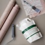 Wallpro Tapetenkleister mit Tapezierwerkzeug (Rolle, Bürste) und Tapetenrollen.